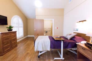 Private resident room with wood furnishings at Arlington Gardens Care Center
