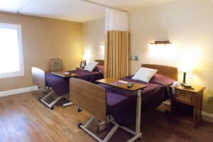 Shared resident room with two beds and privacy curtain at Arlington Gardens Care Center