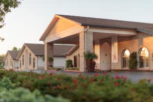 Exterior view of Arlington Gardens with landscaped entrance