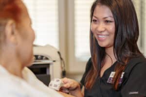 Nurse taking a resident’s vitals at Arlington Gardens Care Center