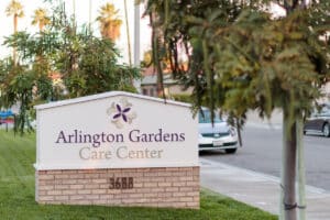 Sign for Arlington Gardens Care Center on a tree-lined street