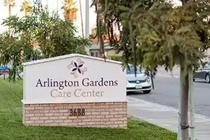 Sign for Arlington Gardens Care Center on a tree-lined street